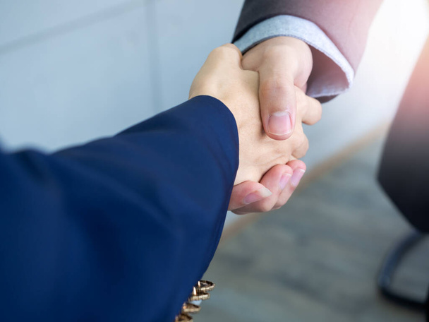 Businessman and businesswoman are shaking hands. Close up hand shake between business people. Collaborative teamwork, greet or thanks gesture, partnership approval, success concept. - Φωτογραφία, εικόνα