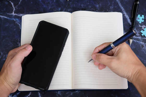 nyitott notebook és a telefon közelről - Fotó, kép