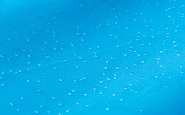 Gota de agua en una tela impermeable azul
 - Foto, Imagen