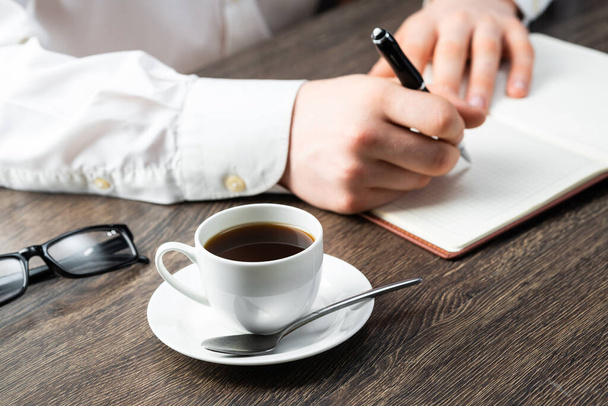 Man making notes with pen in notebook - Φωτογραφία, εικόνα