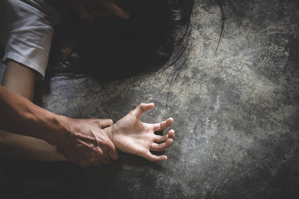 Крупним планом руки чоловіка тримають жіночі руки за концепцію зґвалтування та сексуального насильства. Насильство проти жінок
. - Фото, зображення