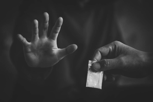 Μια ασπρόμαυρη φωτογραφία με ανθρώπινα χέρια να σταματούν τα ναρκωτικά. Διακοπή της έννοιας της τοξικομανίας. - Φωτογραφία, εικόνα