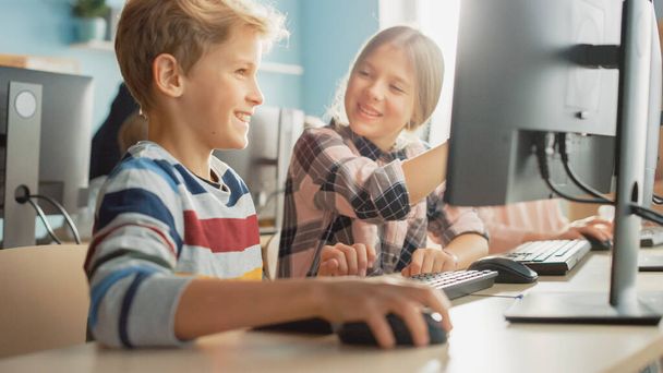 Elementary School Computer Science Classroom: Portrait of Smart Girl and Boy Talking while using Personal Computer, Learning Informatics, Internet Safety, Programming Language for Software Coding - Фото, зображення