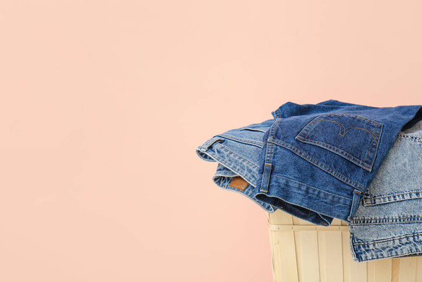 Korb und Jeans Kleidung in der Nähe der Farbwand - Foto, Bild