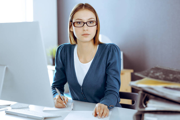 Accountant checking financial statement or counting by calculator income for tax form, hands close-up. Business woman sitting and working at the desk in office. Audit concept - Photo, image