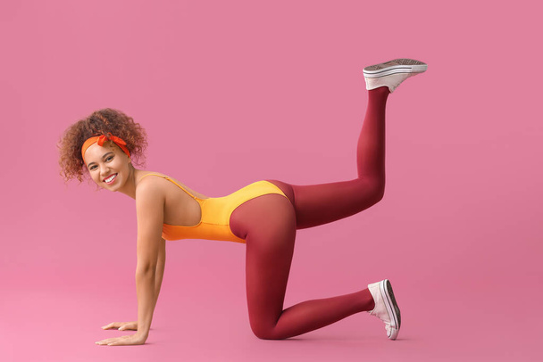 Mladá žena dělá aerobik na barevném pozadí - Fotografie, Obrázek