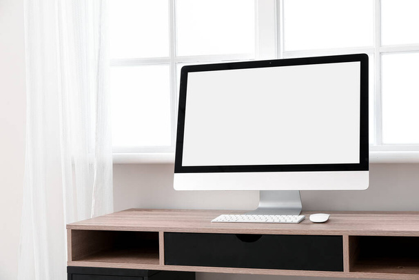 Modern PC monitor on table near window - Foto, imagen