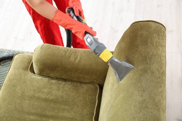 Reinigungskraft entfernt Schmutz vom Sofa im Haus - Foto, Bild