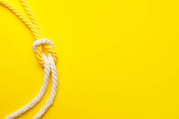Ropes with knot on color background - Fotografie, Obrázek