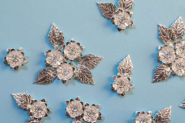 Prachtige verzilverde details voor het creëren van sieraden, naaien en kleding ontwerp. Metalen bloemen en bladeren, close up stock foto - Foto, afbeelding
