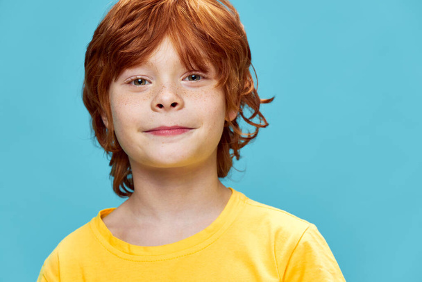 Beautiful red-haired boy smiling on an isolated background  - Fotó, kép