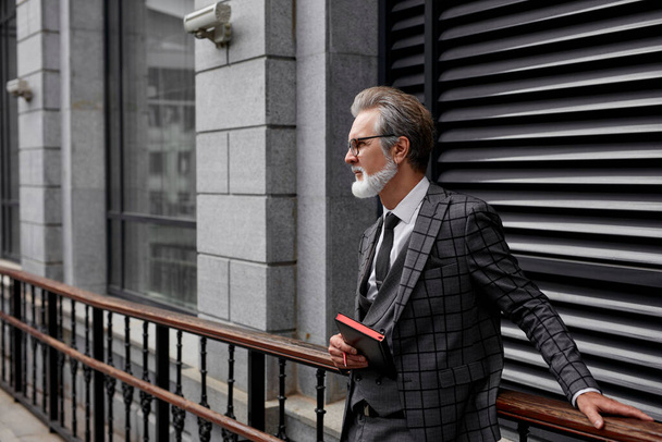 an elegant mature businessman using his notebook - Fotó, kép