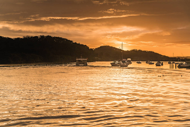Golden Sunrise Waterscape with Clouds and Boats at Woy Woy Waterfront on the Central Coast, NSW, Australia. - Foto, Imagen
