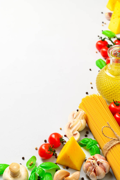 Een set producten voor het koken van Italiaanse pasta met champignons op een lichtgrijze achtergrond. - Foto, afbeelding