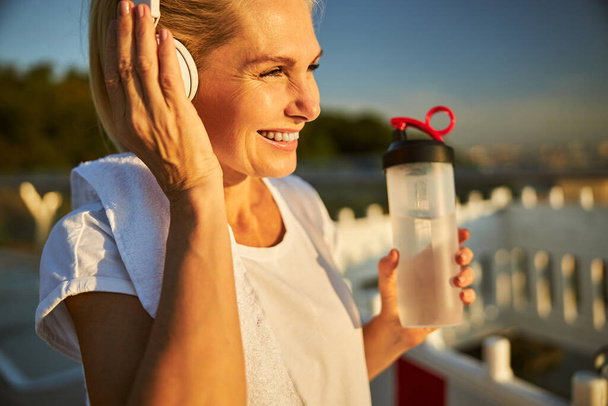 Cheerful woman listening to music on the street - Фото, зображення