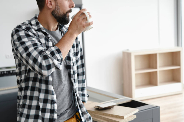 Unrecognizable man drinking cup of coffee during breaks in work                               - 写真・画像