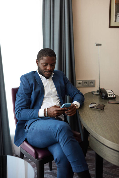 young african businessman sitting on chair in hotel - Φωτογραφία, εικόνα