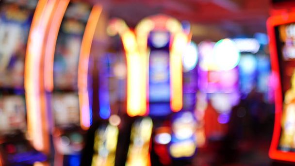 Defocused κουλοχέρηδες λάμψη στο καζίνο στην υπέροχη Las Vegas Strip, ΗΠΑ. Θολή κουλοχέρηδες τζακ ποτ τυχερών παιχνιδιών στο ξενοδοχείο κοντά στην οδό Fremont. Φωτισμένη μηχανή φρούτων νέον για το παιχνίδι με επισφαλή χρήματα και στοιχήματα. - Φωτογραφία, εικόνα