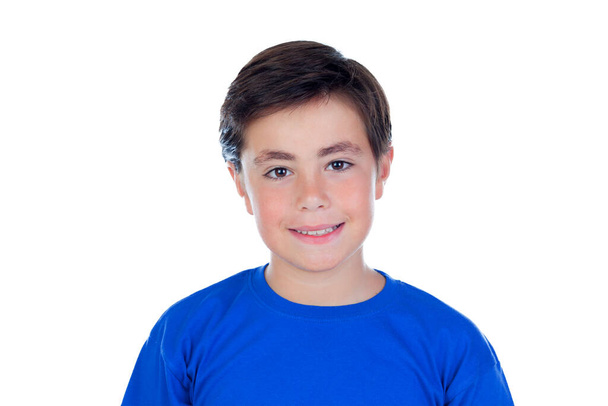 Entzückendes Kind mit blauem T-Shirt, das isoliert auf weißem Hintergrund in die Kamera blickt - Foto, Bild
