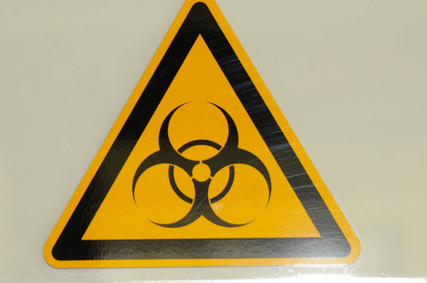 черный знак биологической опасности на желтом фоне, треугольник, опасность для здоровья - Фото, изображение