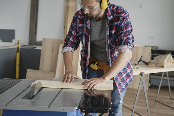 Ξυλουργός κατά τη διάρκεια της εργασίας με δισκοπρίονο                                - Φωτογραφία, εικόνα