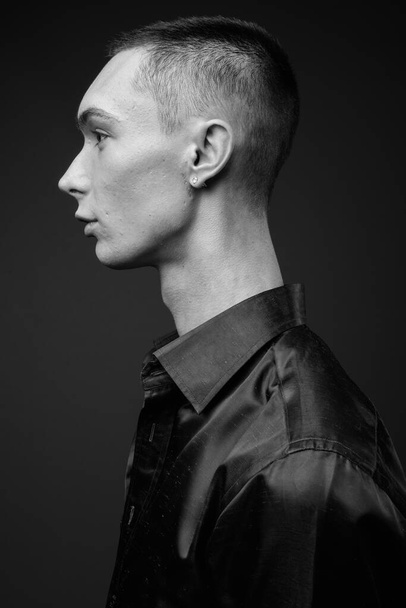 Studio shot de jeune homme d'affaires androgyne beau en chemise de soie sur fond gris en noir et blanc - Photo, image