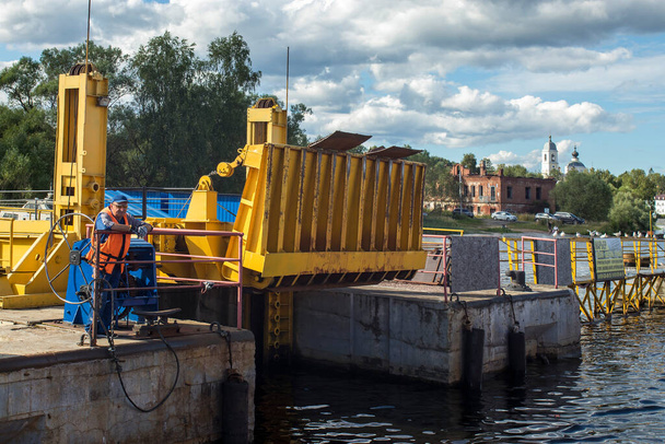 Myshkin, Russia - 26 July 2020, A ferry worker is waiting for the ferry to moor and dock. The passenger is waiting for the end of the trip. - 写真・画像