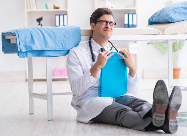 Doctor sitting on the floor in hospital - Foto, Bild