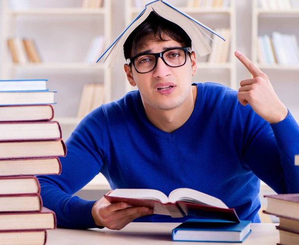 Estudiante masculino preparándose para exámenes en la biblioteca universitaria - Foto, imagen