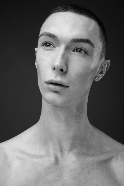 Stúdió lövés fiatal jóképű androgén férfi félmeztelen ellen szürke háttér fekete-fehér - Fotó, kép