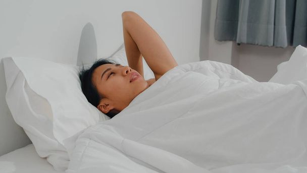 Mujer india asiática dormir en la habitación en casa. Joven chica asiática sintiéndose feliz descansar tumbado en la cama, sentirse cómodo y tranquilo en el dormitorio en la casa por la mañana. - Foto, imagen
