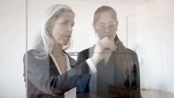 Compañeras de negocios femeninas serias dibujando gráfico de crecimiento - Metraje, vídeo