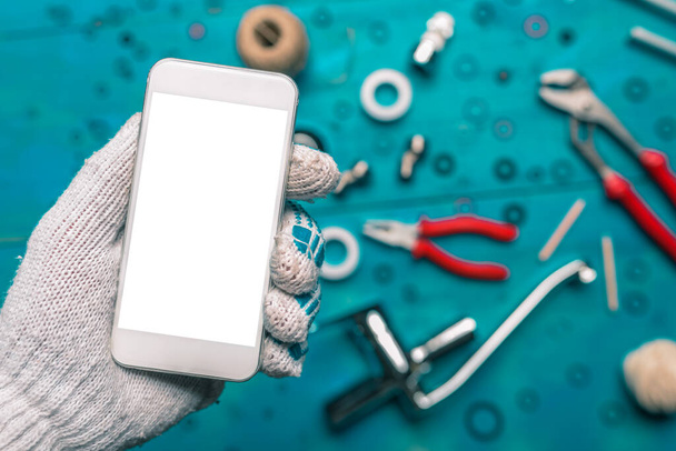 Plumbing app for mobile phones mock up, plumber holding smartphone with blank screen - Photo, image