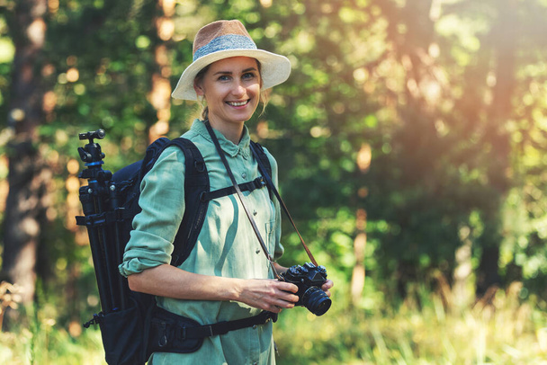 mosolygós női természet fotós analóg film kamera az erdőben - Fotó, kép