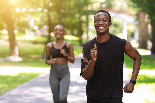 Couple afro-américain actif jogging dans le parc d'été, profiter d'un mode de vie sain - Photo, image