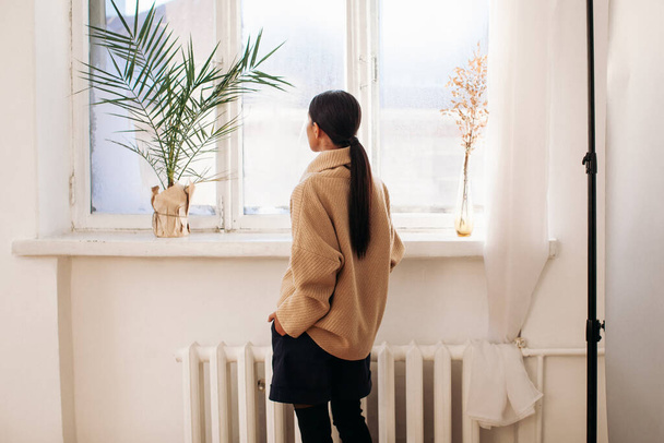 beautiful woman in sweater stay near window at day time  - Valokuva, kuva