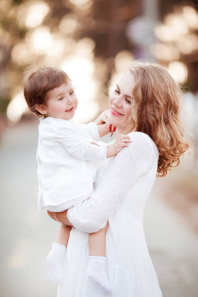 Mutter hält kleine Tochter im Arm - Foto, Bild