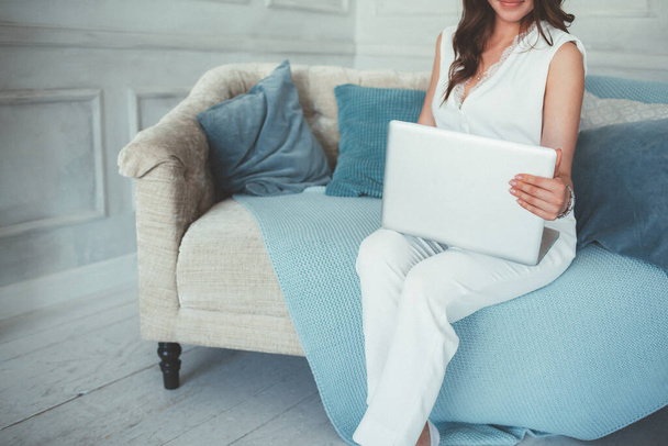 Femme utilisant un ordinateur portable sur le canapé à la maison - Photo, image