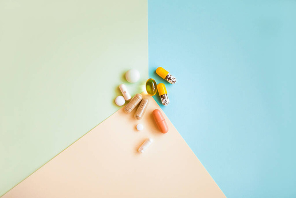 вид сверху различных таблеток и витаминов на цветном фоне - Фото, изображение