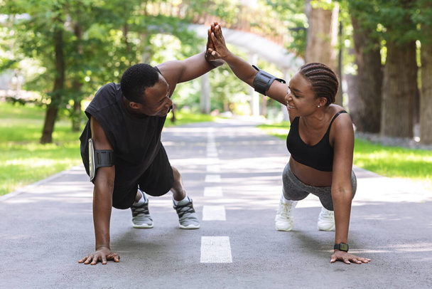 Motivato coppia nera dando il cinque l'uno all'altro mentre si lavora all'aperto - Foto, immagini