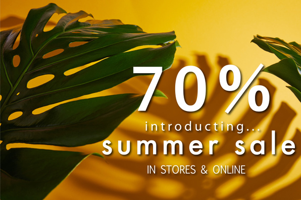 top view of tropical green leaves on yellow background with summer sale illustration - 写真・画像