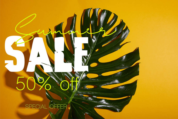 top view of tropical green leaf on yellow background with summer sale illustration - Foto, afbeelding