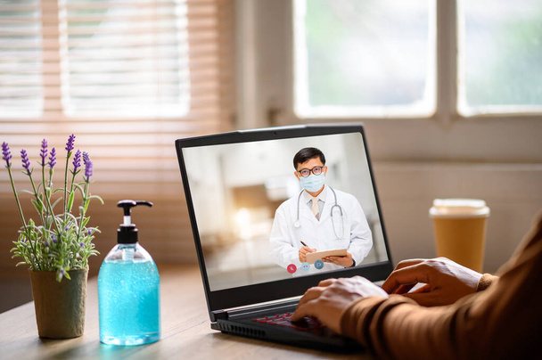 デスクトップ上の男性医師とのビデオ会議のクローズアップ,ヘルスケアの概念 - 写真・画像