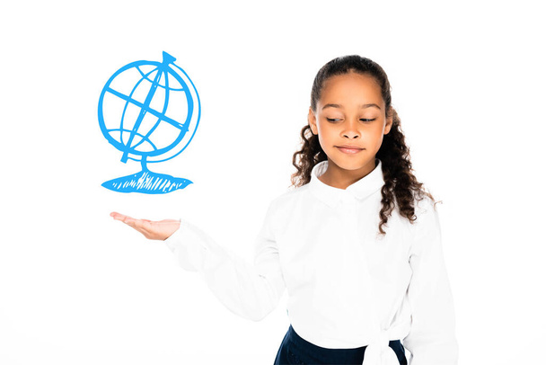 скептически настроенная африканская школьница держит на руках иллюстрированный глобус, изолированный на белом - Фото, изображение