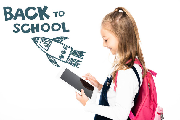 side view of schoolgirl holding digital tablet with blank screen isolated on white, back to school illustration - Foto, afbeelding