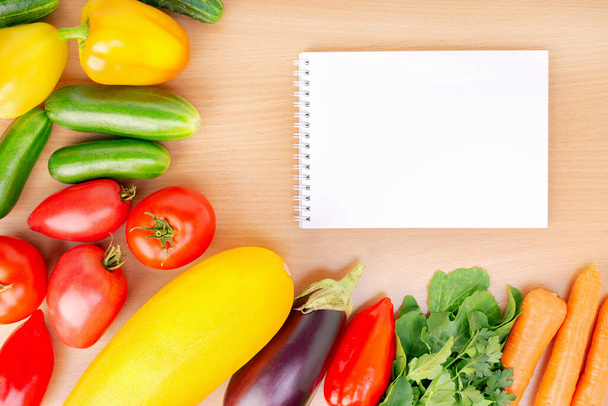 Notebook and fresh vegetables on table. - Photo, image