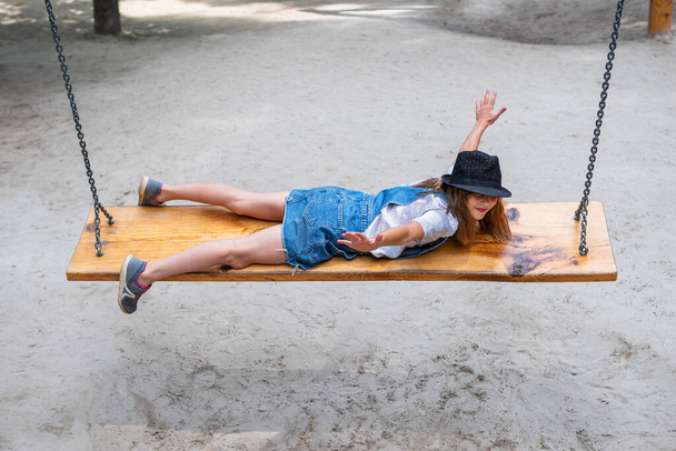 girl lying rides on a swing - Foto, immagini