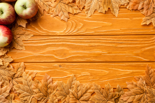 top view of ripe apples and autumnal foliage on wooden background - Фото, зображення