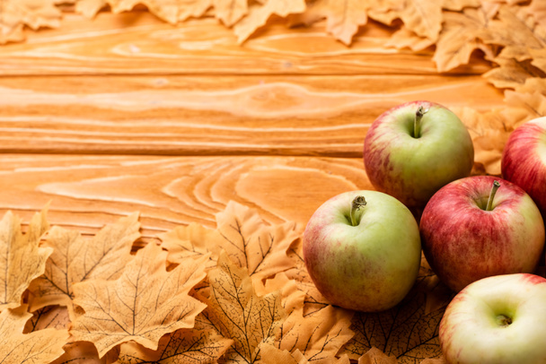 ripe apples and autumnal foliage on wooden background - Photo, Image