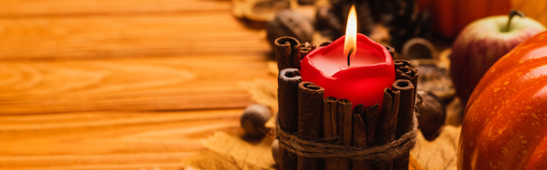 selective focus of burning candle with autumnal decoration on wooden background, panoramic shot - Photo, Image